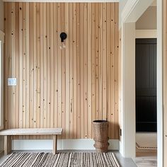 a room with wood paneling and a bench in the corner next to a door