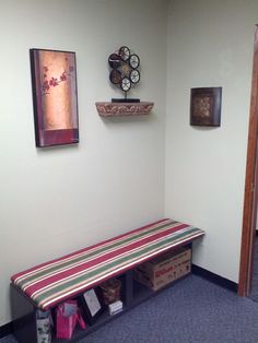 a room with a bench, clock and pictures on the wall