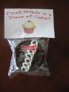 there is a bag of cupcakes on the table with a sign that says first grade is a piece of cake