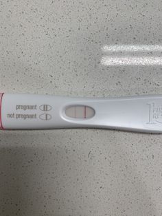 an electronic thermometer on a counter top with writing that reads, pregnant not pregnant