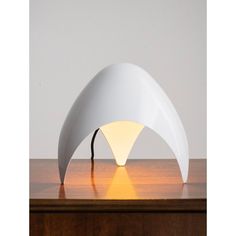 a white lamp sitting on top of a wooden table