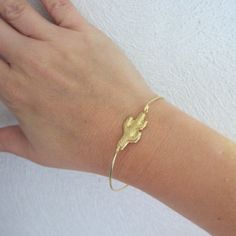 "Saguaro Cactus Bracelet - Southwestern Bracelet - Southwest Jewelry - Arizona Jewelry - A gold tone saguaro cactus charm has been transformed into a saguaro cactus bangle bracelet with a brass band for you to wear. I can also make this Southwestern bracelet with a 14k gold filled bangle band for an additional $10. If you would like this option for your cactus jewelry, select from options when ordering. This cactus bracelet looks great when paired with other bangles from my collection as you can Southwestern Adjustable Gold Bracelets, Adjustable Southwestern Gold Bracelets, Cactus Bracelet, Arizona Jewelry, Cactus Jewelry, Southwest Jewelry, Saguaro Cactus, Brass Band, Cactus Flower