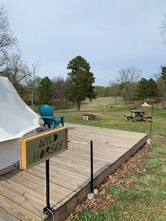 there is a sign that says wild horses on the wooden deck next to a tent