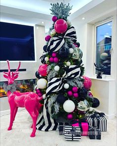 a christmas tree decorated with pink, black and white ornaments