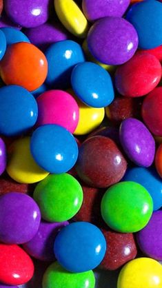 there are many different colored candies on the table