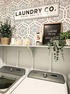 a washer and dryer sitting next to each other in front of a laundry sign