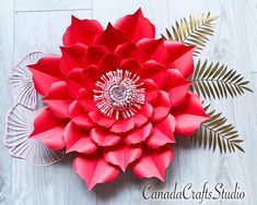 a large red flower sitting on top of a wooden table