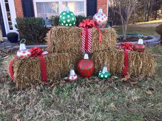 hay bales with christmas decorations on them in front of a house