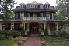 a large house with lots of flowers in front of it