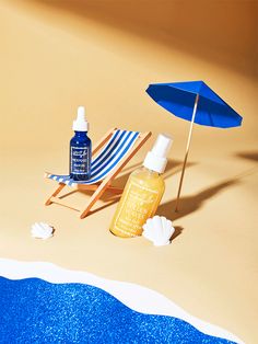 a blue umbrella and some sunscreens on a beach