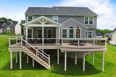 a large house with a deck in the grass