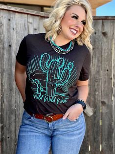 Turquoise Puff Ink Design by Texas True Threads Cactus design with Wild Wild West on the bottom Perfect western design True to size fit Available on a Brown tee or Burnt Orange Western Style Blue Relaxed Fit Tops, Western Blue Relaxed Fit Tops, Weastern Tshirts, Western Tshirt Designs, Black Short Sleeve Western Tops, Black Western Crew Neck Top, Turquoise Short Sleeve Top With Relaxed Fit, Graphic Tee With Screen Print For Western-themed Events, Turquoise Relaxed Fit Short Sleeve Top