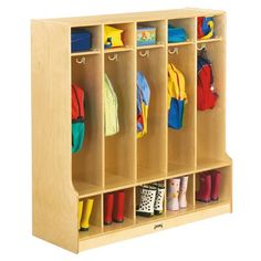 a wooden locker with several coats and boots