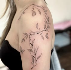 a woman with a butterfly tattoo on her arm and shoulder is looking at the camera