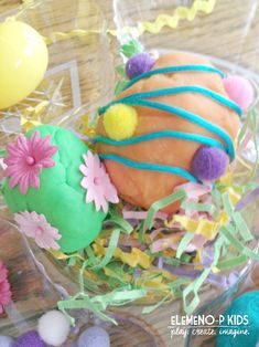 there is a cake decorated with flowers and grass on top of the table next to eggs