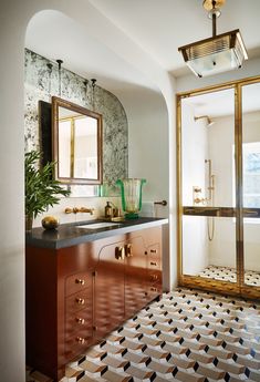 a bathroom with a sink, mirror and tiled flooring in it's center