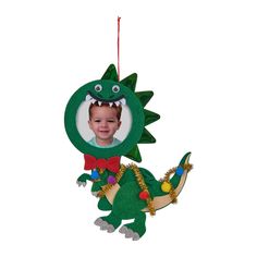 a christmas ornament with a photo of a boy in a green dinosaur costume