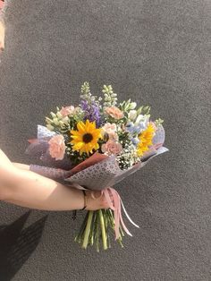 a woman is holding a bouquet of flowers