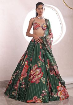 Elevate your Mehendi look with this modern lehenga, featuring an exquisite green printed skirt with statement motifs and a chic bralette blouse. The embellished waistband adds a touch of glamour, perfectly complemented by the intricate print and embellishments on the dupatta. This modern lehenga is designed to grace your mehendi festivities with elegance and charm. Composition : Lehenga, Blouse, Dupatta - Organza, Shandon Care: Dry Clean Only and Vacuum Storage This product can be customized for sleeves, length of blouse and neckline Delivery : 4-6 weeks as the product is hand crafted. Check Size Guide or choose MySize for free customisation (All Sizes above XL can be made at 15% additional cost) For more information and sizes please contact fabiliciousfashion@gmail.com or visit our Copenh Mehendi Look, Modern Lehenga, Mahima Mahajan, Lehenga Style Saree, Indian Bridesmaid Dresses, Cut Blouse, Green Lehenga, Lehenga Style, Vacuum Storage