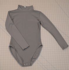 "Custom made to order mock turtleneck leotard top in our custom Williams Studio 2 gray color. The fabric is a modern nylon /spandex supplex fabric that is soft with a great stretch. It dries fast and has top notch coverage when stretched. It is as close to the original color used in the 60's tights for a popular crime fighter as you will find! A quote, \"Hey Chuck, I just taped with Burt Ward yesterday! He specifically and in an unsolicited way pointed out the new tunic/tights as being very accu High Stretch High Neck Leotard, High Neck Stretch Leotard, Second-skin Turtleneck Bodysuit With Thumbholes, High Neck Solid Color High Stretch Unitard, High Stretch High Neck Solid Color Unitard, High Stretch High Neck Solid Unitard, High Stretch Leotard With Thumbholes, Stretch Turtleneck Bodysuit With Thumbholes, High Stretch Solid Leotard With Thumbholes