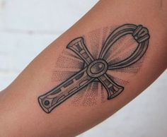 a tattoo on the arm of a person with a cross and wrench in it