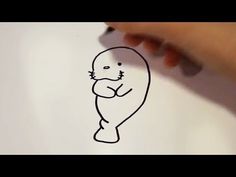 someone is drawing a cartoon seal on paper