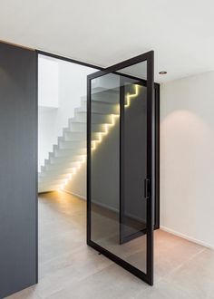 an open door leading to a staircase in a room with white walls and flooring