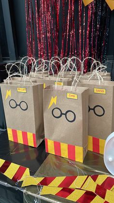 some harry potter bags on a table with red and yellow streamers hanging from them