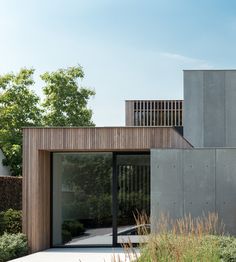 an exterior view of a modern house with wood and concrete sidings on the outside