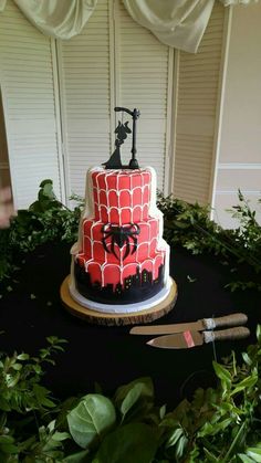 a three tiered cake with spiderman on top