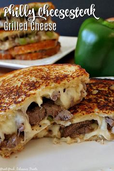 grilled cheese sandwich cut in half on a white plate with green bell peppers behind it