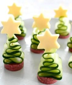 cucumber and cheese christmas trees are arranged on a white platter with green icing