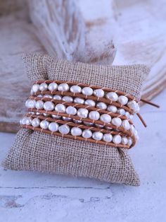 Beautiful genuine freshwater pearls are woven into these always on-trend leather pearl wrap bracelets. Wearing one of these bracelets will make you feel casually elegant since the pearls give a classy look to a traditionally bohemian style wrap bracelet. Choose from white pearls on natural tan leather or white pearls on dark brown leather. This pearl bracelet wraps around the wrist 5 times and is adjustable closure for flexible sizing. Bracelets are approximately 37 inches long and are adjustabl Elegant Adjustable Hand Wrapped Pearl Bracelet, Elegant Brown Wrap Bracelet As A Gift, Handmade Adjustable Luxury Pearl Bracelet, Elegant Beaded Leather Bracelet Gift, Elegant Brown Hand Wrapped Leather Bracelet, Handmade Elegant Leather Bracelet, Elegant Handmade Leather Bracelet, Elegant Hand Wrapped Leather Bracelet, Elegant Hand Wrapped Leather Bracelet Gift