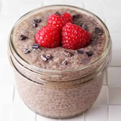 two raspberries on top of chocolate chia pudding in a glass jar