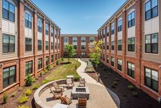 an apartment building courtyard with seating and landscaping