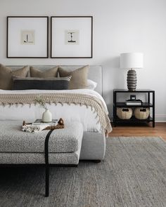 a bedroom with two framed pictures on the wall and a bed in the foreground