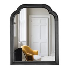 a mirror with a yellow chair in front of it and a white door behind it