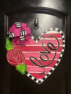 a heart shaped door hanger with the word love painted on it's side