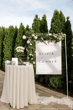 a table with a sign that says ollivia conner on it and flowers