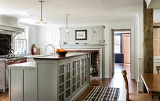 a kitchen with white cabinets and an island in the middle, along with a dining room table