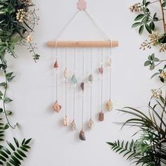 a white wall with some plants and beads hanging from it