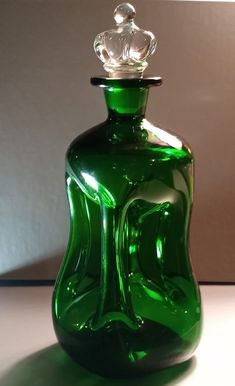 a green glass bottle sitting on top of a table