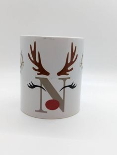 a close up of a coffee cup with reindeer antlers painted on it's face