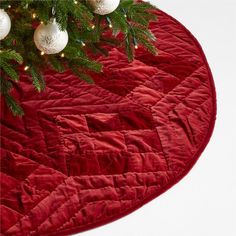 a christmas tree skirt with ornaments hanging from it