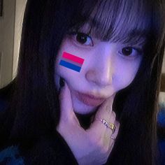 a girl with her face painted in the colors of the flag of thailand and red, blue, and white