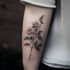 a black and white photo of a rose tattoo on the right arm, with leaves around it