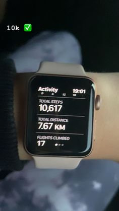 an apple watch with the time displayed on it's display screen, in someones hand