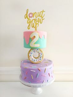 a birthday cake with sprinkles and a donut on top that says donut drop 2