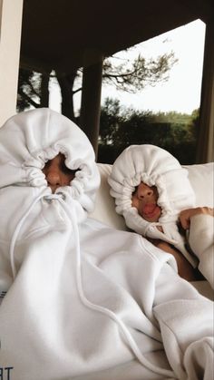 two baby dolls are wrapped in white blankets