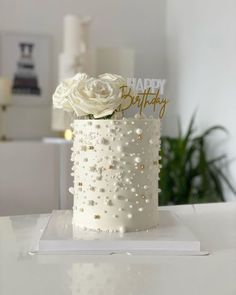 a birthday cake decorated with white flowers and sparkles